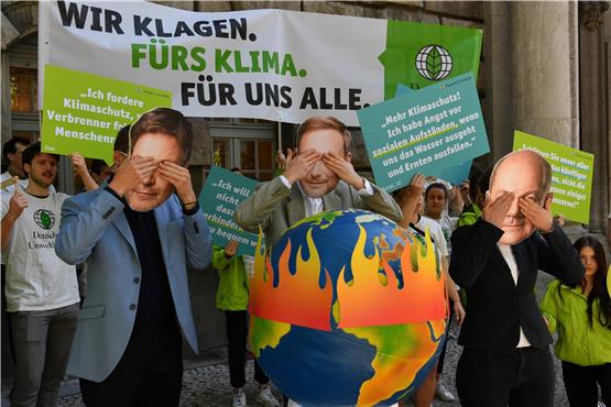 Aktivisten der Deutschen Umwelthilfe (DUH) protestieren vor dem Oberverwaltungsgericht. Foto: Paul Zinken/dpa