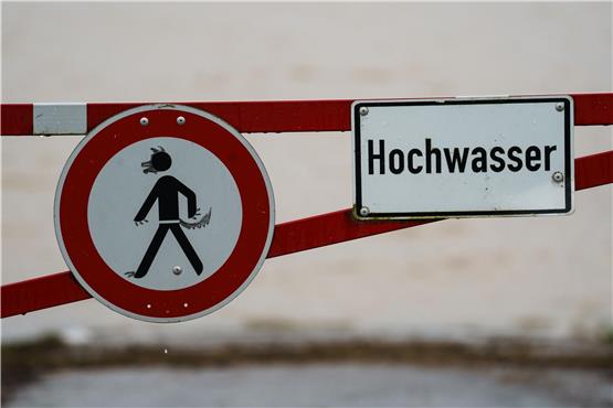 Ein Hochwasser-Schild steht an einem überfluteten Feld. Foto: Andreas Arnold/dpa/Symbolbild