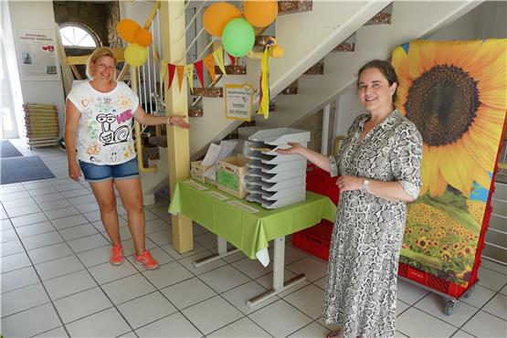 Anja Schäfer (links) und Ute Hahn vor den Aufgaben-Kisten fürs diesjährige Seebronner Sommerferienprogramm. Bild: Werner Bauknecht