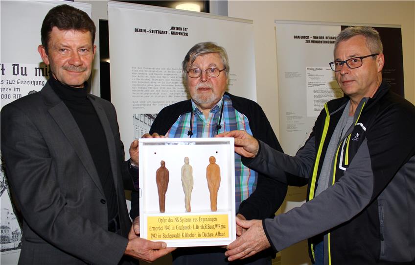 Bei der Ausstellungseröffnung am Donnerstag überreichten Helmut Schäfer (Mitte) und Rainer Molitor (rechts) vom Ergenzinger Heimatkreis eine Erinnerung an die drei in Grafeneck ermordeten Männer an Ortsvorsteher Reinhold Baur (links).Bild: Stifel