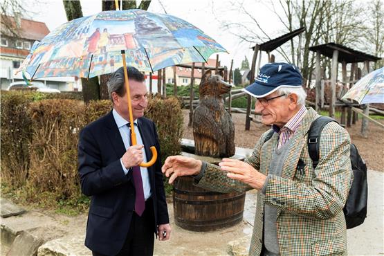 Beschirmt von Kemmler-Schirmen ließ sich Günther Oettinger (links) von Willi Kemmler die Entstehung eines Vorzeige-Projekts der Gomaringer Bürgerstiftung zeigen, den Halden-Spieleplatz. Bild: Klaus Franke