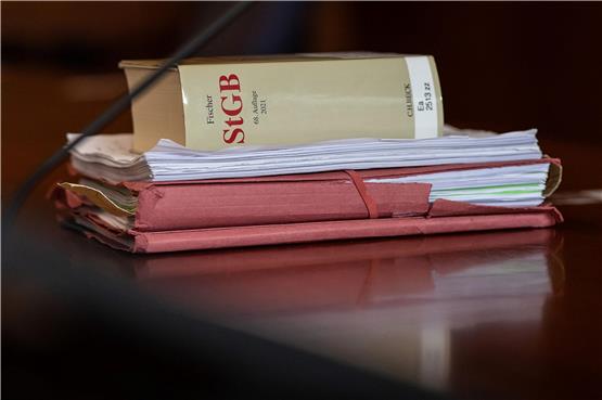 Das Strafgesetzbuch und Akten liegen in einem Gericht auf dem Tisch. Foto: Swen Pförtner/dpa/Symbolbild