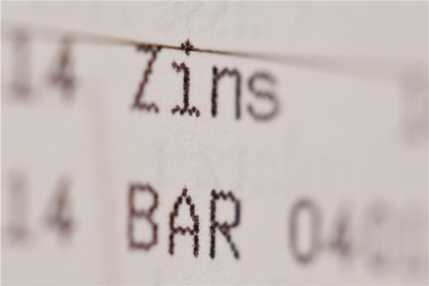 Die Einträge «Zins» und «Bar» sind in einem Sparbuch zu sehen. Foto: Daniel Karmann/Archiv dpa/lsw