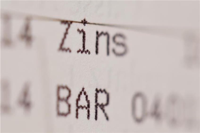 Die Einträge «Zins» und «Bar» sind in einem Sparbuch zu sehen. Foto: Daniel Karmann/Archiv dpa