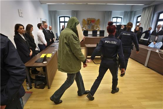 Ein Mann (M) wird im Landgericht in einen Gerichtssaal geführt. Er wird gemeinsam mit seiner Frau des Doppelmordes beschuldigt. Foto: Karl-Josef Hildenbrand/dpa