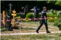 Ein Polizist geht über den abgesperrten Teil an einem Tatort auf einem Friedhof im Juni 2023. Foto: Christoph Schmidt/dpa