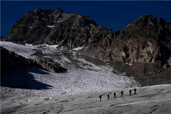 Eine Gruppe von Wanderern wandert auf dem Jamtalferner-Gletscher bei Galtür. Foto: Matthias Schrader/AP/dpa