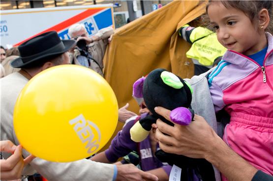 Flüchtlinge werden am 5. September 2015 am Münchner Hauptbahnhof mit Handreichungen empfangen. Ein Mädchen bekommt ein Stofftier und einen Ballon geschenkt.Privatbild