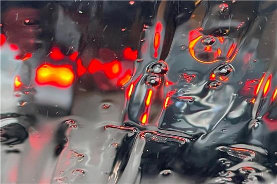 Graupelkörner sind auf der Windschutzscheibe eines Autos, das in einem Stau steht, zu sehen. Foto: Marijan Murat/dpa