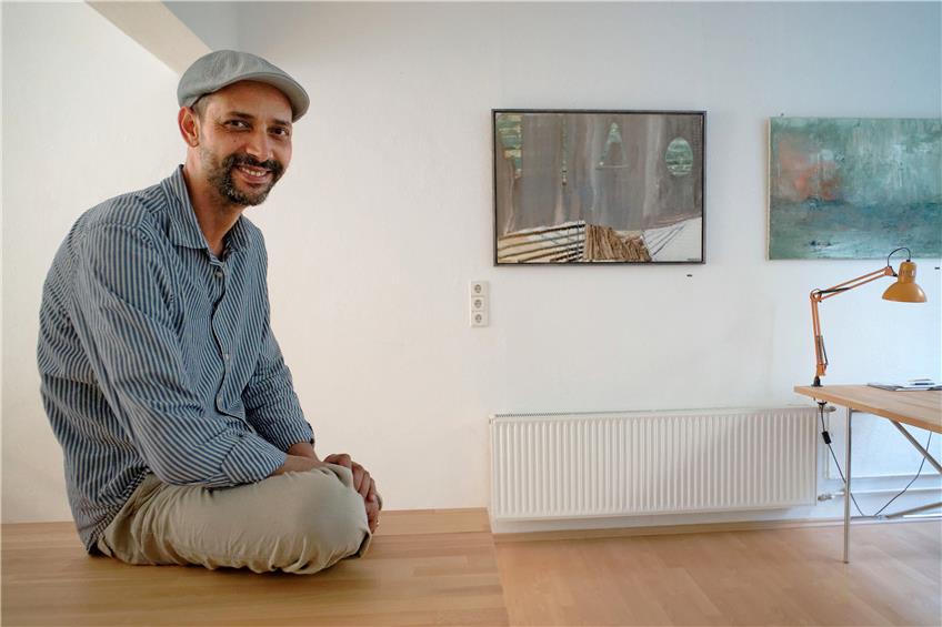 Imed Ben Tahar neben zweien seiner Bilder. Die Motive findet er erst im Akt des Malens. Bild: Metz