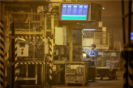 Mitarbeiter der Handtmann Leichtmetallgießerei Annaberg GmbH arbeiten an einer Druckgußmaschine. Foto: Jan Woitas/dpa