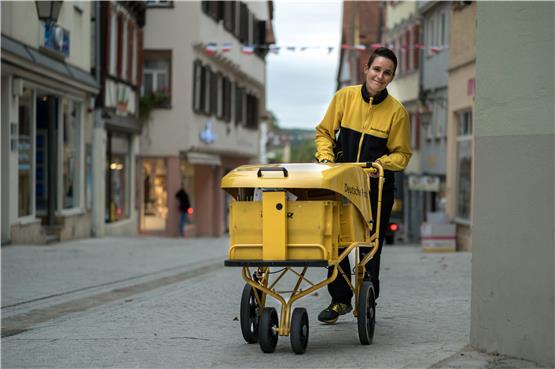 Nur nicht aus dem Rhythmus bringen lassen: Gut gelaunt schiebt Doreen Hackbarth ihren Postwagen durch die Neckargasse. Bild: Metz