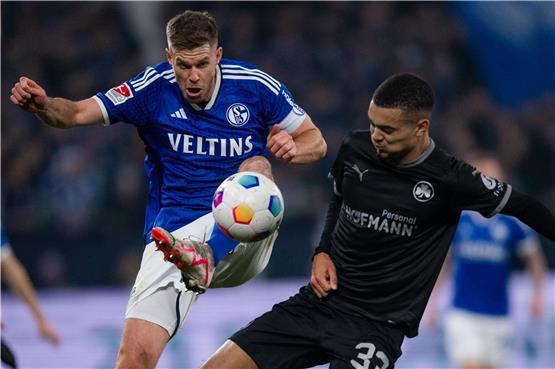 Schalkes Simon Terodde (l) und Greuter Fürths Maximilian Dietz kämpfen um den Ball. Foto: Marius Becker/dpa