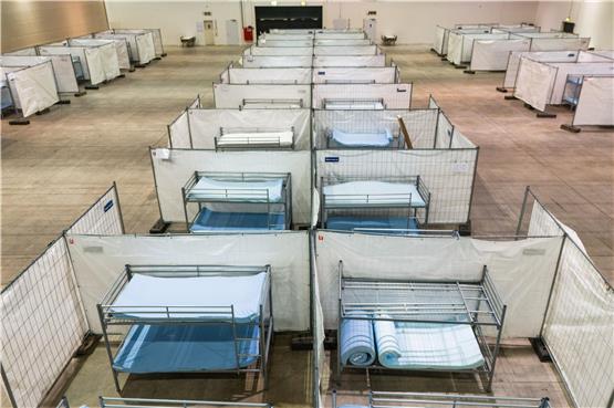 Stockbetten stehen in einer Notunterkunft für Asylsuchende in einer Messehalle. Foto: Philipp von Ditfurth/dpa/Symbolbild