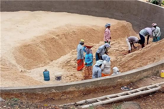Tagelöhner befüllen ein Filterbecken mit feinem Sand. Im Hintergrund ist bereits ein zweites Becken vorbereitet. Bild: Jojappa Ramisetti