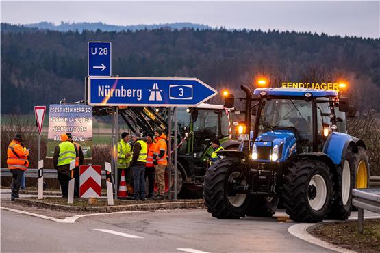 Traktoren von protestierenden Landwirten blockieren nahe Kirchroth die Auffahrt zur Autobahn A3 Richtung Nürnberg. Foto: Armin Weigel/dpa