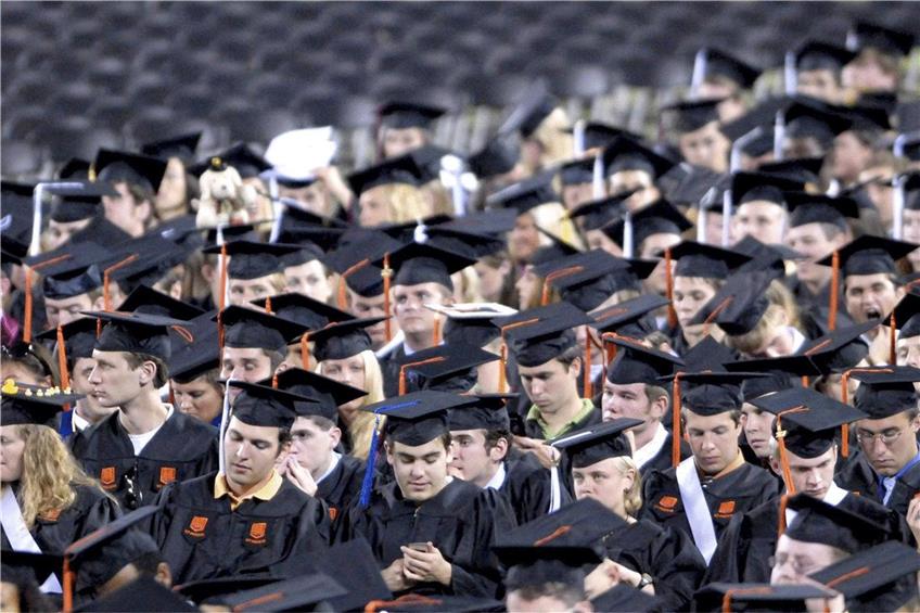 US-Studenten tragen bei ihrer Abschlussfeier im Lane-Stadion in Blacksburg, Virginia, Talare und die typischen Kopfbedeckungen. Foto: dpa