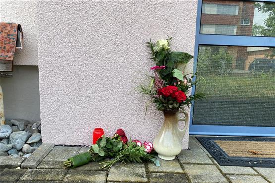 Vor dem Mehrfamilienhaus, in dem die getötete 22-Jährige lebte, haben Leute Blumen und eine Kerze abgelegt. Bild: Jacqueline Schreil