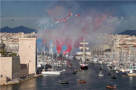 Während das Segelschiff „Belem“ mit der olympischen Flamme in Marseille einläuft, wird ein Feuerwerk gezündet. Die Spiele werden in diesem Jahr auf Abstand gefeiert.  Laurent Cipriani/dpa/AP