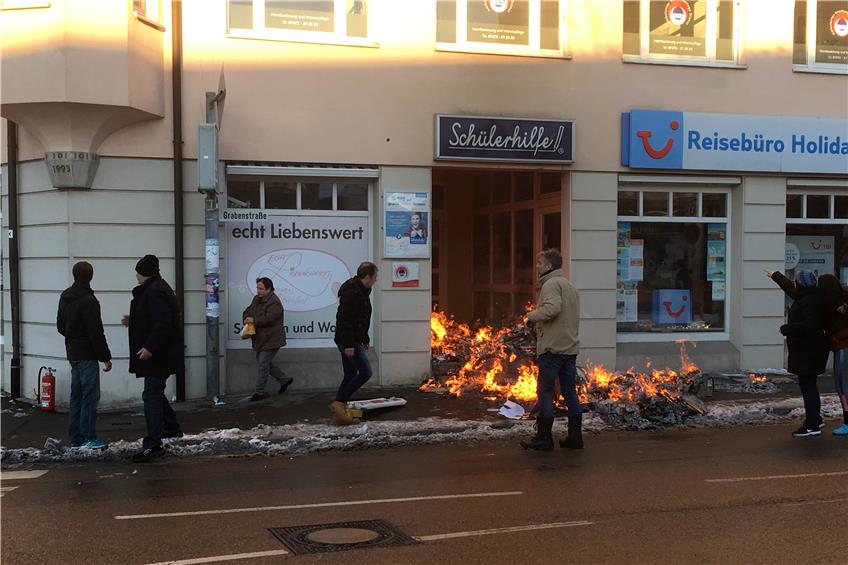 16.01 Uhr: Im Eingangsbereich des Geschäftsgebäudes brennt Altpapier.