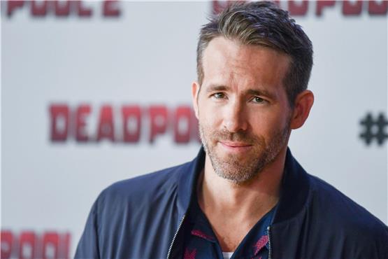 ARCHIV - 11.05.2018, Berlin: Ryan Reynolds, Schauspieler, kommt zu einem Pressetermin zum Film «Deadpool 2» und steht vor einem Filmplakat. (zu dpa: «Diese Highlights kommen 2024 ins Kino») Foto: Jens Kalaene/dpa-Zentralbild/dpa +++ dpa-Bildfunk +++ Jens Kalaene