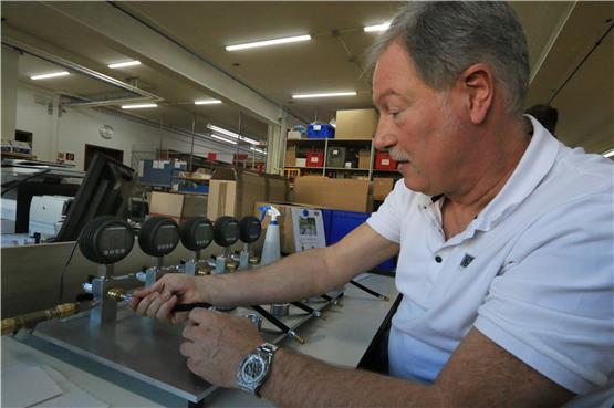 Achim Leitenberger, einer der beiden Geschäftsführer der Leitenberger Gruppe, testet ein Manometer. Dabei wird ein Vakuum erzeugt, Prüfadapter und Schlauch werden dabei auf Dichtigkeit geprüft. Unten ist ein Kompressionsdruckprüfgerät für Motoren abgebildet. Bild: Manfred Hantke