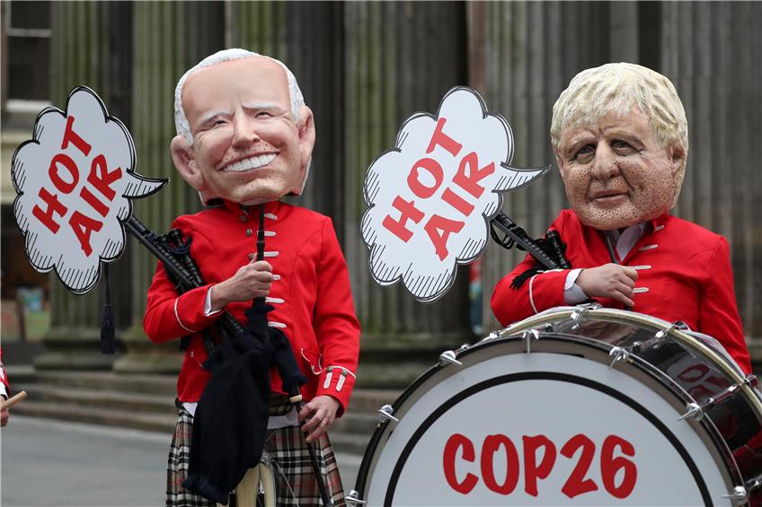 Aktivisten demonstrieren mit Masken, die Joe Biden und Boris Johnson darstellen sollen, am Rande des UN-Klimagipfels in Glasgow. Foto: Scott Heppell/AP/dpa