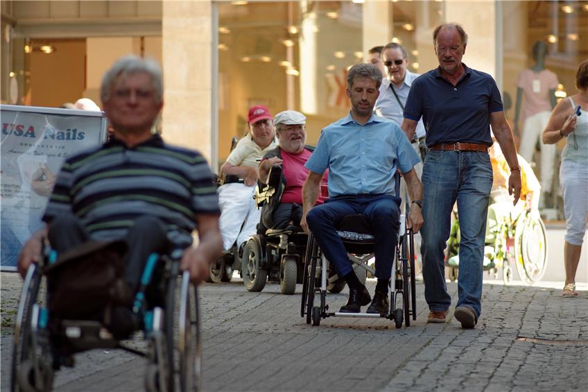Alexander Breitung unterstützte Boris Palmer dabei, mit dem Rollstuhl unterschiedliche Straßenbeläge und Steigungen in der Altstadt auszuprobieren. Der Vorsitzende des RSKV, der auch schon mit vielen BG-Patienten trainierte, behielt aber vorsichtshalber die Hand stets am Griff. Bild: Metz