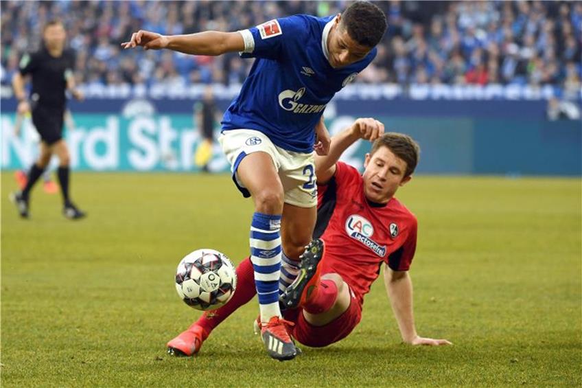Amine Harit von Schalke gegen Dominique Heintz (r) von Freiburg. Foto: Ina Fassbender dpa