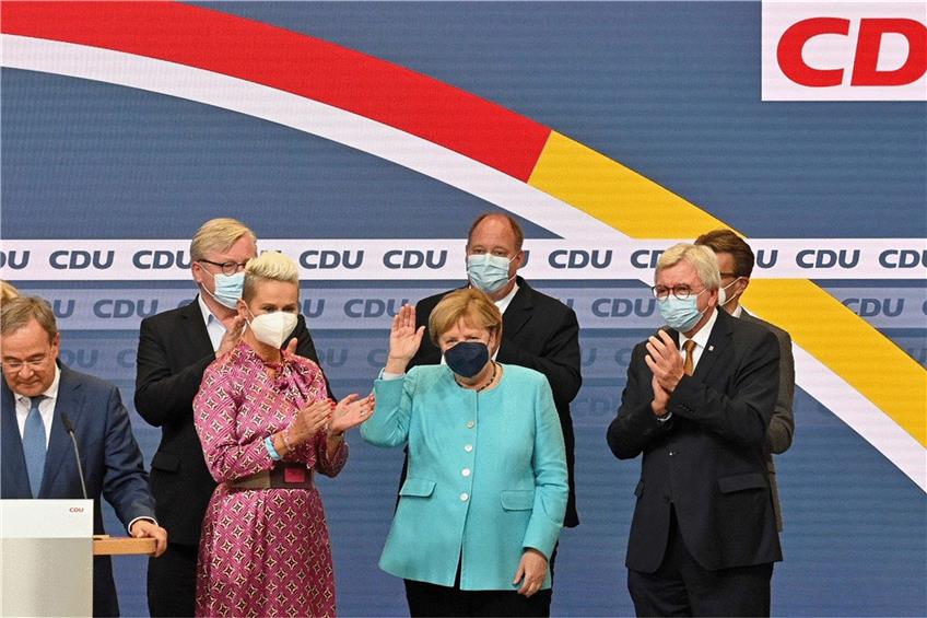Armin Laschet (links) geht nur knapp auf die Niederlage ein. Den größten Applaus im Konrad-Adenauer-Haus bekommt Bundeskanzlerin Angela Merkel (rechts). Zwischen ihnen Silvia Breher aus Laschets „Zukunftsteam“. Foto: John Macdougall/afp