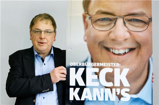 Ausnahmsweise mal ohne Fliege: OB-Kandidat Thomas Keck vor seinem Wahlkampfplakat mit dem selbstbewussten Slogan. Bild: Haas