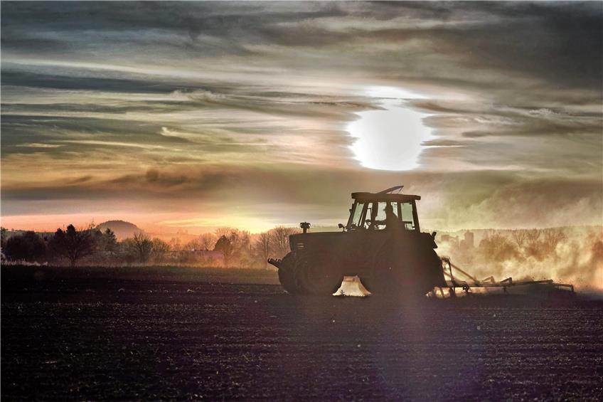 Bauer mit dem Traktor bei der Feldarbeit. Bild: Metz