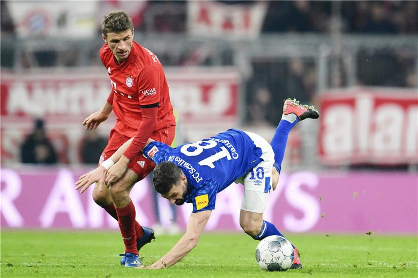 Bayerns Thomas Müller (l.) bringt Schalkes Daniel Caligiuri ins Straucheln. Foto: Foto:Tobias Hase/dpa
