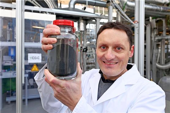Benjamin Dietrich, Geschäftsführer des Instituts für Thermische Verfahrenstechnik beim Karlsruher Institut für Technologie, zeigt Kohlenstoff, der mit einer Versuchsanlage aus CO2 der Umgebungsluft gewonnen wurde.  Foto: Uli Deck/dpa