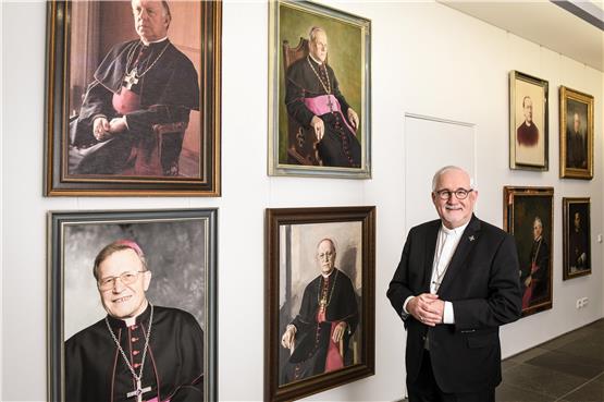 Bischof Gebhard Fürst vor der Galerie seiner Vorgänger in der Diözese Rottenburg-Stuttgart.  Foto: Julia Steinbrecht/kna