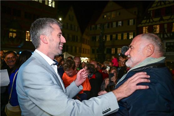 Boris Palmer (l) bekommt nach seiner Wiederwahl auf dem Marktplatz Glückwünsche von Rezzo Schlauch. Foto: Bernd Weißbrod/dpa/Archivbild