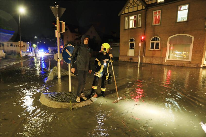 Bürgermeister Bernd Haug (links) beobachtete von einer Verkehrsinsel aus, wie das Hochwasser langsam zurückging. Bilder: Manfred Grohe