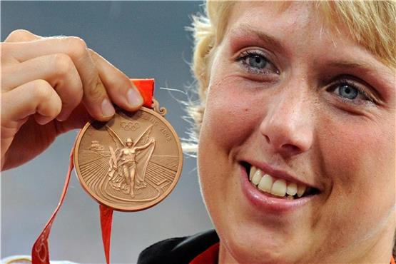 Christina Obergföll zeigt ihre Bronzemedaille im Speerwurf bei den Olympischen Spielen 2008. Foto: Gero Breloer/Archiv