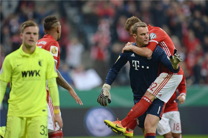 Danke, Manuel! Bayerns Jungnationalspieler Joshua Kimmich gratuliert dem Kollegen Neuer zu dem     gehaltenen Elfmeter im Pokalspiel gegen Augsburg. Foto: dpa