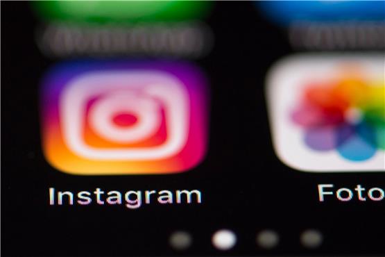 Das Logo des Fotonetzwerks Instagram (l) ist auf dem Bildschirm eines iPhones zu sehen. Foto: Silas Stein/dpa