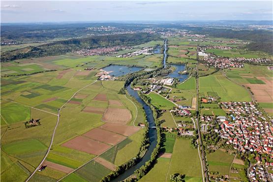 DasNeckartal von Kiebingen (rechts vorn) bis Tübingen. Dort wo der Fluss eine Ausbuchtung nach links macht, stehen das Kiebinger E-Werk (direkt am Wasser) und rechts daneben die Kläranlage. Darüber ist als weiße Fläche das frühere Betonmischwerk Queck zu sehen, links davon Richtung Neckar sind Lagerflächen. Dieses Areal plus das grüne Dreieck rechts davon bis zur Bahnlinie empfiehlt Ottmar Raidt für ein Gewerbegebiet. Entlang der Bahn wird die B28 neu gebaut. Rechts der Bahn liegen die Gewerbegebiete „Bonlanden“ (Bühl) und die Firma Siemens (Kilchberg), links des Neckars recht ausgedehnt der „Rittweg“ (Hirschau). Das Gebiet „Galgenfeld/Herdweg“ kann man sich rechts unterhalb Kiebingens denken. Luftbild: Grohe