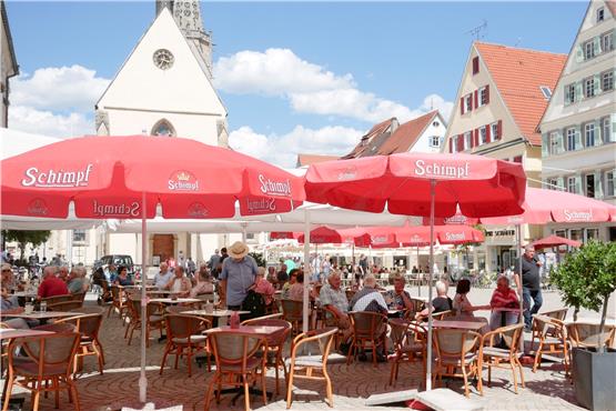 Den Rottenburger Marktplatz teilen sich Eiscafés, Marktstände, Bücherauslagen und durchfahrende Busse – so gut es geht. Bild: Angelika Bachmann