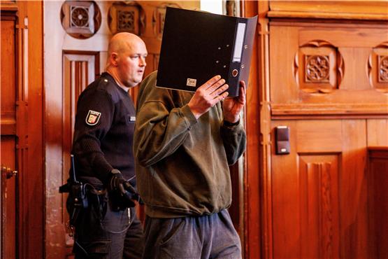 Der 54-jährige Angeklagte wird in den Gerichtssaal geführt.  Foto: Axel Heimken/dpa