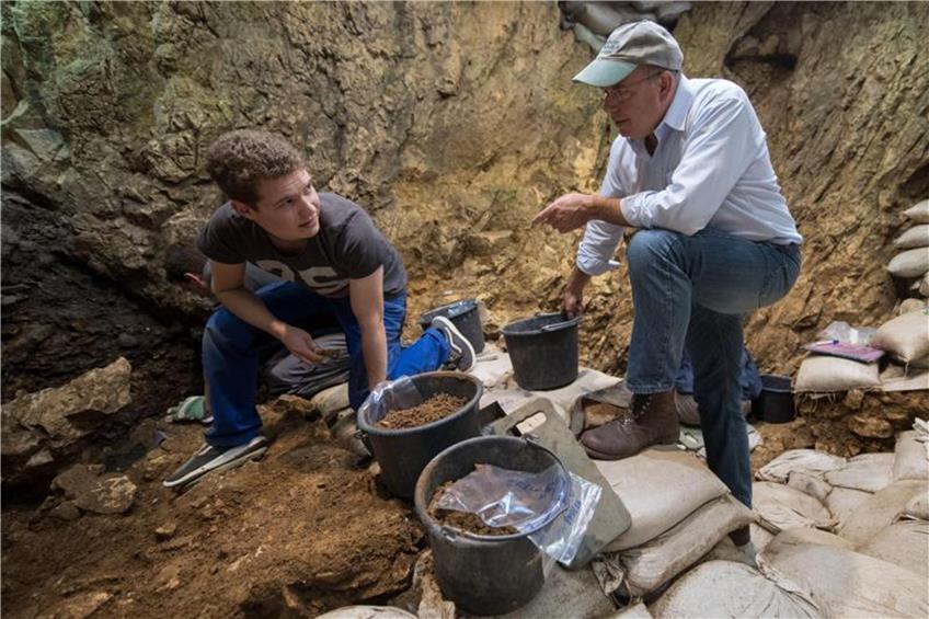 Der Archäologe Nicholas Conard (r) unterhält sich im Grabungsbereich der Höhle „Hohle Fels“ mit einem Archäologiestudenten. Foto: Marijan Murat/Archiv