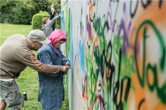 Der Graffiti-Künstler Marco Neumann zeigt Jasmin, wie sie die Sprühdose halten soll. Bild: Ulrich Metz