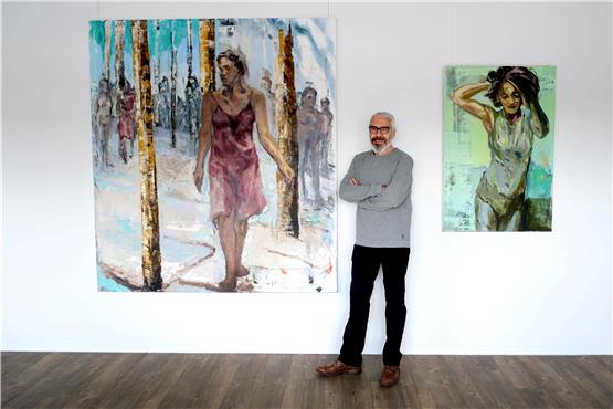 Der Künstler Michael Plaetschke zeigt seine Bilder im Dußlinger „Werk II“. Hier steht er zwischen „Viele sind wir“ und „Grüner Morgen“ (rechts). Bild: Uli Rippmann