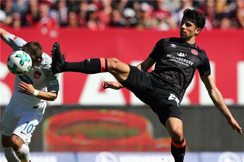 Der Nürnberger Lukas Mühl (r.) kämpft mit dem Heidenheimer Nikola Dovedan um den Ball. Foto: Daniel Karmann dpa/lby