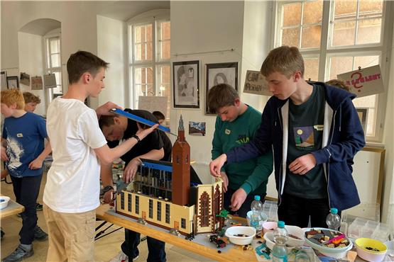 Der Rottenburger Dom aus Lego ist eine besonders große Herausforderung. Von links Nico, Felix, Daniel, Philip und Finn. Der Baum hinten am Chor der Kirche steht schon.Bild: Jana Breuling