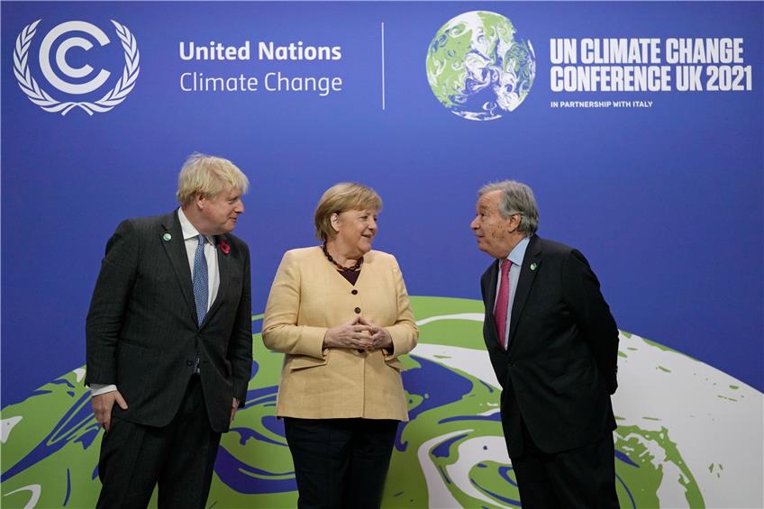 Der britische Premierminister Boris Johnson (links) und der Generalsekretär der Vereinten Nationen, Antonio Guterres, begrüßen die geschäftsführende Bundeskanzlerin Angela Merkel (CDU). Foto: Alastair Grant/Pool AP/dpa