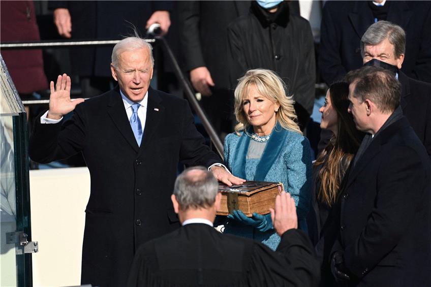 Der neue US-Präsident Joe Biden (l.), begleitet von seiner Frau Jill Biden, legt seinen Amtseid ab. Foto: Saul Loeb/Pool/afp